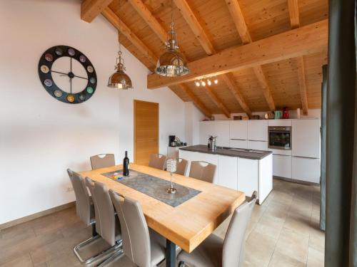 kuchnia i jadalnia z drewnianym stołem i krzesłami w obiekcie Luxury penthouse in Brixen im Thale with Parking w mieście Brixen im Thale