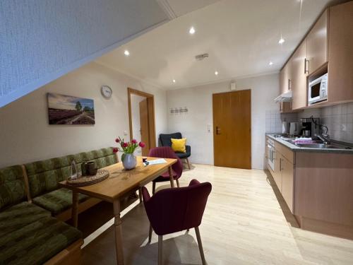 a kitchen and living room with a table and a couch at Heidhof in Bispingen