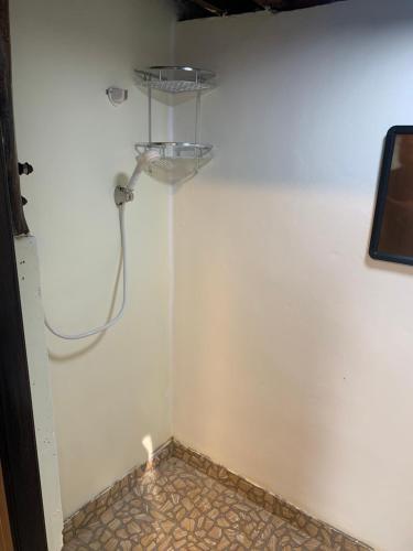 a shower in a room with a white wall at NADOHN2 Nai Fan Homestay in Rayong