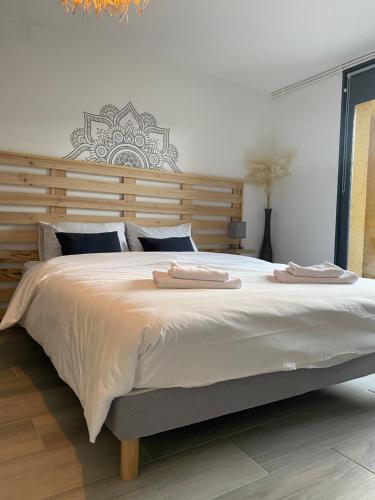 1 dormitorio con 1 cama grande y 2 toallas. en Maison chaleureuse au cœur du village Raddon, en Raddon-et-Chapendu