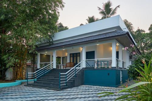 a house with a blue and white facade at Seclude by the Lake, Alleppey in Alleppey
