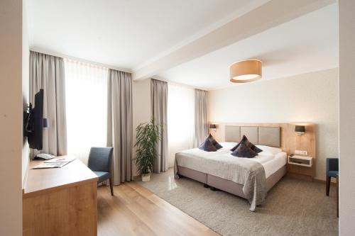 ein Hotelzimmer mit einem Bett und einem Schreibtisch in der Unterkunft Hotel Restaurant Bullerdieck in Garbsen