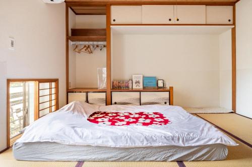 a bed with red roses on it in a room at Dat's house in Tokyo