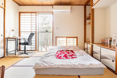 a bedroom with a bed and a desk and a chair at Dat's house in Tokyo