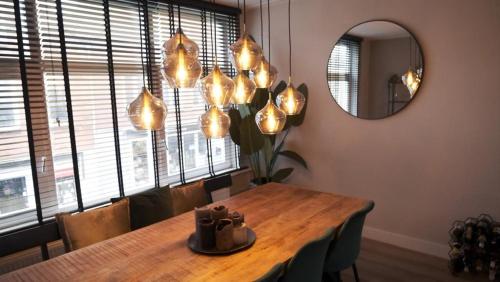 une salle à manger avec une table et un miroir dans l'établissement 't Sand Apartment, à Zandvoort