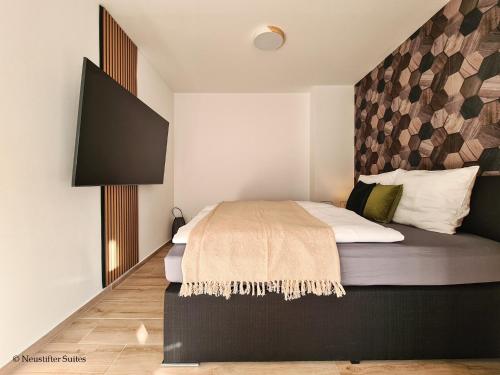 ein Schlafzimmer mit einem großen Bett und einem wandmontierten TV in der Unterkunft St. Antoni Suite 2 in Eisenstadt