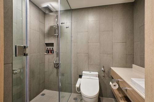 a bathroom with a shower and a toilet and a sink at Sotetsu Grand Fresa Saigon in Ho Chi Minh City