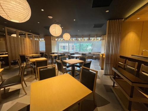 a dining room with tables and chairs and lights at Sotetsu Grand Fresa Saigon in Ho Chi Minh City