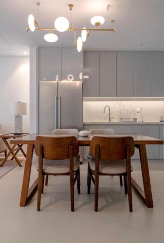 a kitchen with a wooden table and two chairs at شقة فاخرة في فندق العنوان ريزدينس Two bedrooms apartment at address residences in Sharm