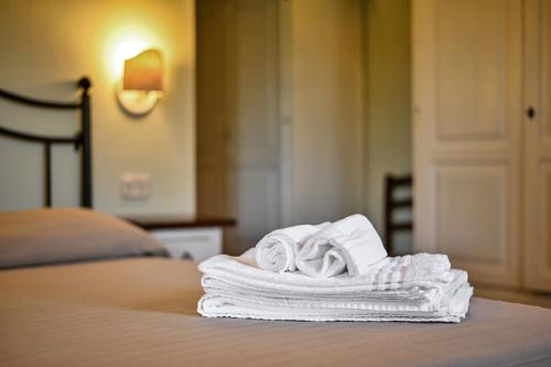 uma pilha de toalhas sentadas em cima de uma cama em Rosaspina - Appartamento 1 em Capalbio
