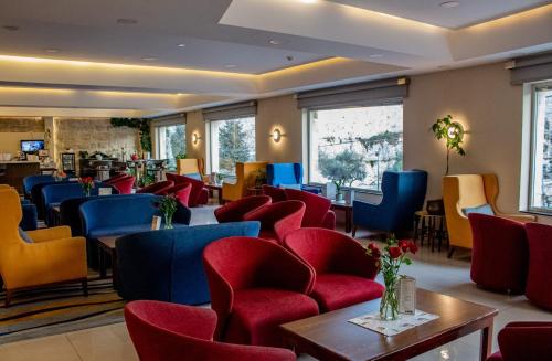 - une salle d'attente avec des chaises rouges et bleues dans l'établissement Golden Walls Hotel, à Jérusalem