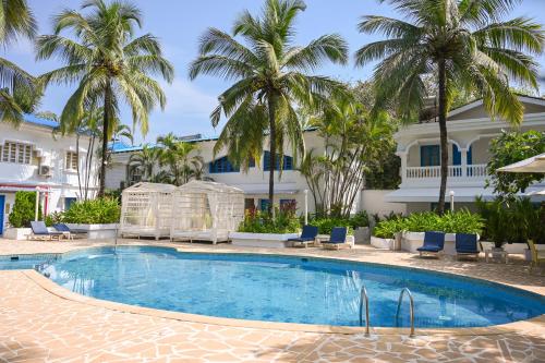 a pool in front of a building with palm trees at Soul Vacation Resort and Spa,Colva in Colva