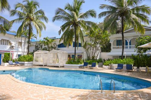 einem Pool vor einem Gebäude mit Palmen in der Unterkunft Soul Vacation Resort and Spa,Colva in Colva