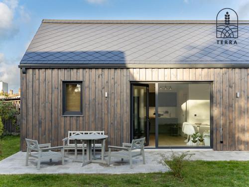 un pequeño edificio de madera con mesa y sillas en Terra House en Ventspils