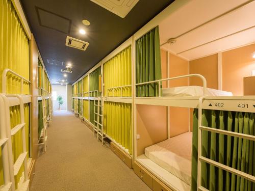 einen Flur eines Schlafsaals mit Etagenbetten in der Unterkunft Hotel Plus Hostel SAPPORO in Sapporo