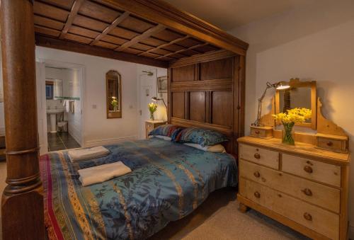 a bedroom with a bed and a dresser with a mirror at Mountain Church in Capel Curig