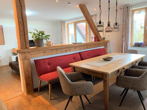 ein Esszimmer mit einem Holztisch und Stühlen in der Unterkunft Fe Wo Brunnen - 120 qm- ruhige Lage - viel Natur - komfortabel - grosser Balkon und Garten in Memmingen