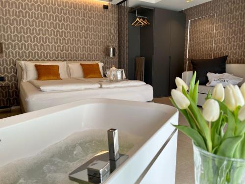 ein Wohnzimmer mit einer Badewanne und einer Couch in der Unterkunft Relais Limonaia - Suites & Garden SPA in Torri del Benaco