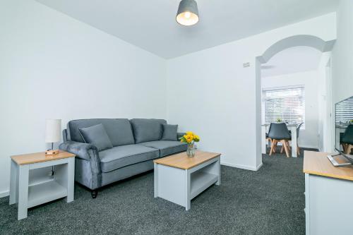 uma sala de estar com um sofá e duas mesas em Fairlands lodge em Stevenage