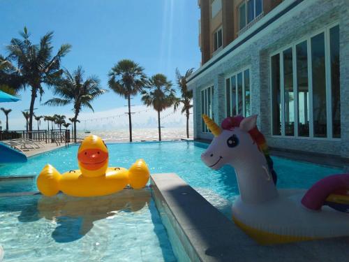 a swimming pool with two toy animals in the water at Saisawan Beach Luxury Hotel in Na Jomtien