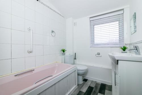 ein Badezimmer mit einer Badewanne, einem WC und einem Waschbecken in der Unterkunft Fairlands lodge in Stevenage