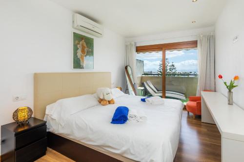 Un dormitorio con una cama con un osito de peluche. en Apartamento Vista Mar en Alcúdia