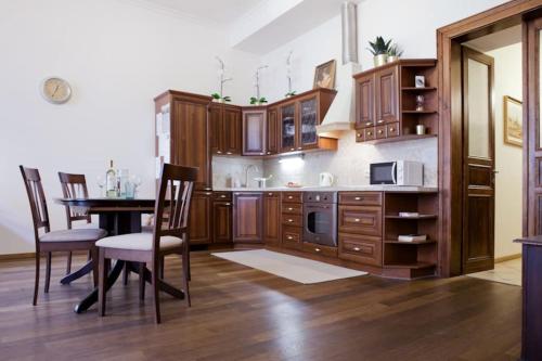 a kitchen with wooden cabinets and a table with chairs at Rhythm and style in Prague city center Andel in Prague