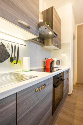 a kitchen with stainless steel appliances and wooden cabinets at Baracca Apartment in Massa Lombarda