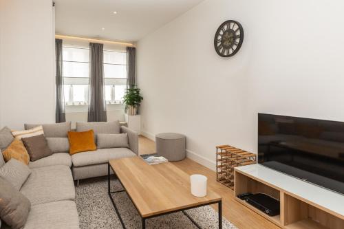 a living room with a couch and a tv at Vakantiehuis Vélolit in Oudenaarde