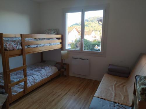 a bedroom with two bunk beds and a window at Maison bien située et au calme in Gap