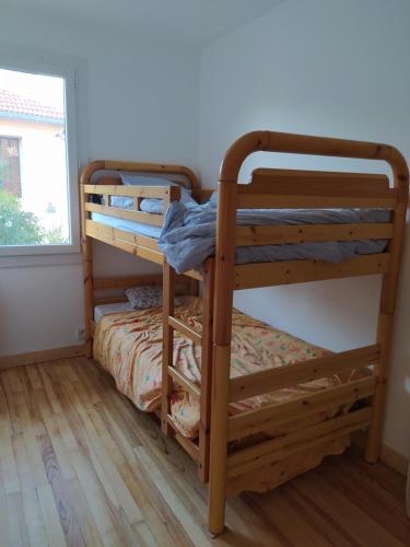 two bunk beds in a room with a window at Maison bien située et au calme in Gap