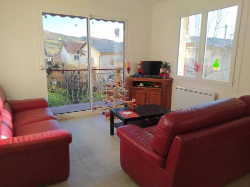 een woonkamer met twee rode banken en een tafel bij Maison bien située et au calme in Gap