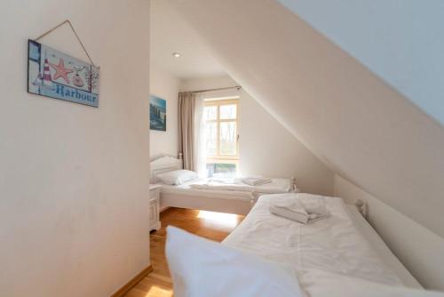 a white room with two beds and a window at Ferienhaus Karnin B in Karnin (Usedom)