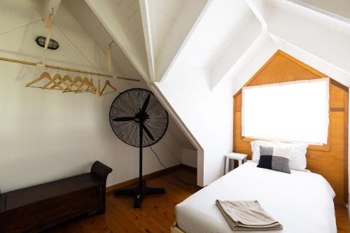 a room with two beds and a clock on the wall at THE MAINSTAY FARMSTAY Unique Aussie Farmstay, Seal Rocks, Barrington Coast in Neranie