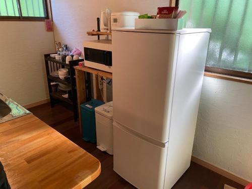 um frigorífico branco numa cozinha com um micro-ondas em Yamato inn - Vacation STAY 86368v em Amami