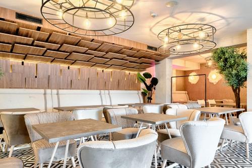 a restaurant with tables and chairs and lights at Citi Hotel's Łódź in Łódź