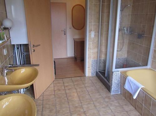 ein Bad mit 2 Waschbecken und einer Dusche in der Unterkunft Ferienwohnungen Tenge in Hooksiel