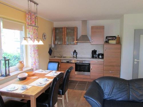 a kitchen with a wooden table and a dining room at Ferienwohnungen Tenge in Hooksiel