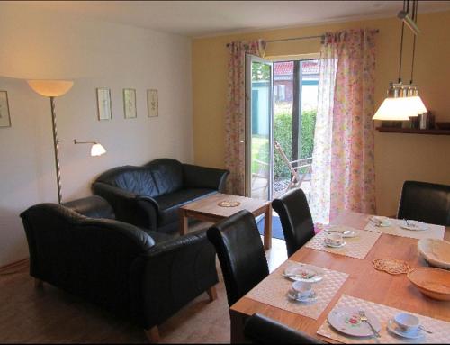 a dining room with a table and chairs at Ferienwohnungen Tenge in Hooksiel