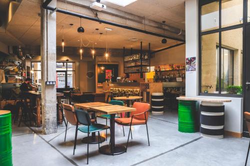 un restaurant avec une table et des chaises ainsi qu'un bar dans l'établissement ARTYSTER CLERMONT-FERRAND, à Clermont-Ferrand