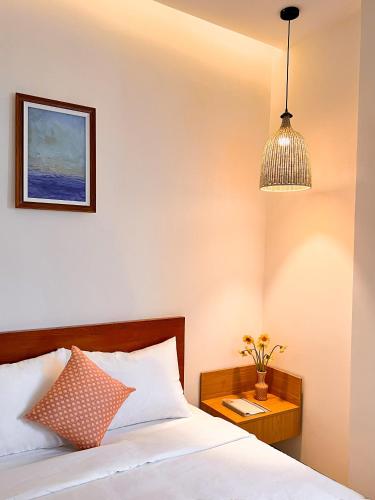 a bedroom with a bed and a pendant light at Tuna Hotel Phú Yên in Liên Trì (3)