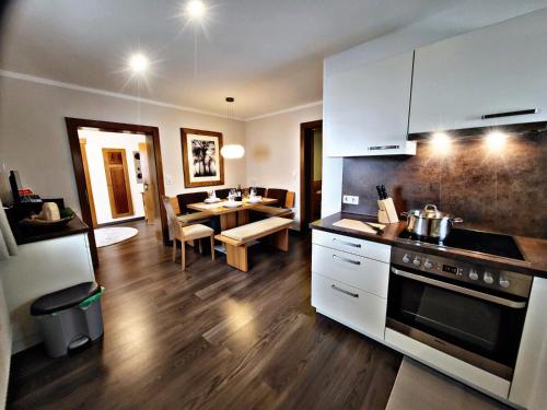 a kitchen and living room with a table and a stove at Lebensquelle Krapfenhof in Finkenberg