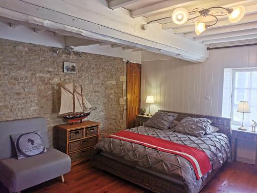 een slaapkamer met een bed en een stoel erin bij Villa Athéna,séjour bien-être et éthique in Meuvaines