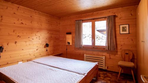 Un dormitorio con una cama en una habitación de madera. en Stachelbeere OG, en Fiesch