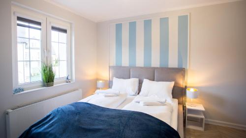 a bedroom with two beds and a striped wall at Apartamenty Sun & Snow Stare Miasto Ustka in Ustka