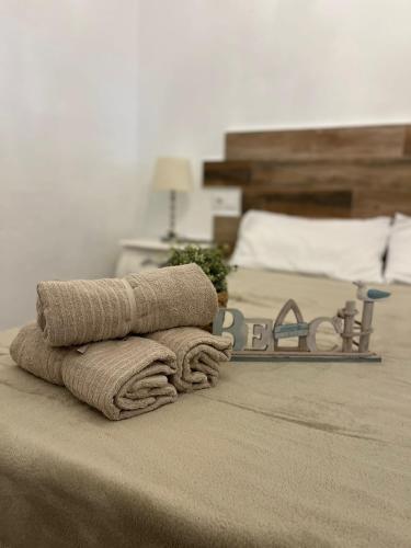 a pile of towels on a bed in a bedroom at Casa en primera linea de playa in Puzol