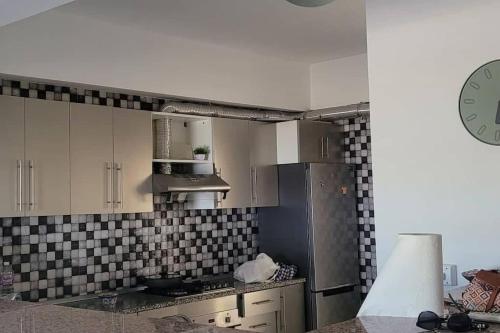 a kitchen with black and white tiles on the wall at Appartement à Bizerte in Bizerte