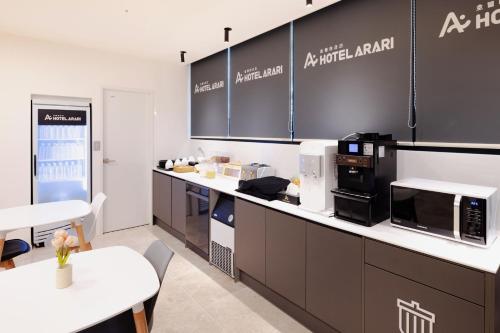 a kitchen with a counter with appliances and a table at Hotel Arari in Jeonju