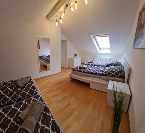a attic bedroom with two beds and a window at Superior Maisonette-Wohnung-nur 5 min zum Europapark in Kappel-Grafenhausen