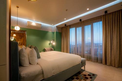 a bedroom with a large bed and a large window at Damask Resort in Jabal Al Akhdar